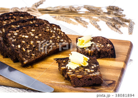 Rye bread with grains and butter on wooden kitchen Rye bread with grains and butter on wooden kitchen 38081894