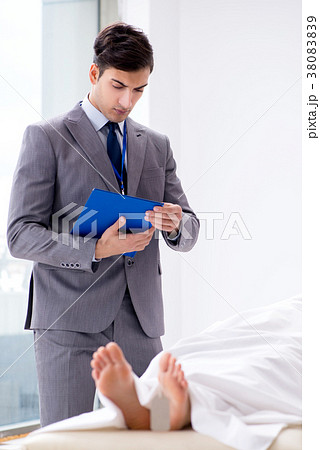 Police coroner examining dead body corpse in Police coroner examining dead body corpse in 38083839