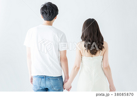 手をつなぐカップルの後ろ姿の写真素材