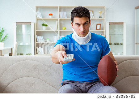 Man with neck injury watching american football at Man with neck injury watching american football at 38086785