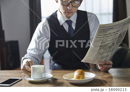 英字新聞を読みながらコーヒーを飲むお洒落なビジネスマン 英字新聞を読みながらコーヒーを飲むお洒落なビジネスマン 38090213