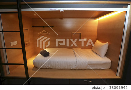 Bed in small simple hotel bedroom 38091942