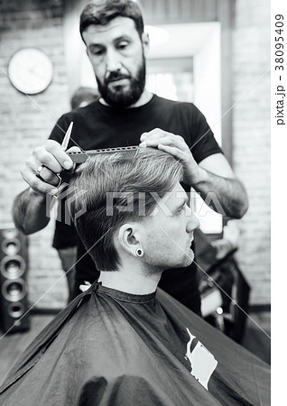 man getting trendy haircut at barber shop. 38095409