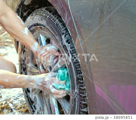 Hands holding microfiber cleaning the car's wheel Hands holding microfiber cleaning the car's wheel 38095851