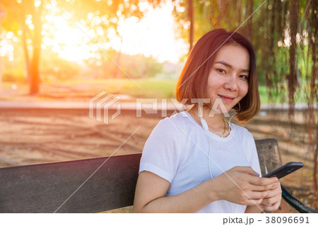 Asian Teen smile listening music from her Phone 38096691