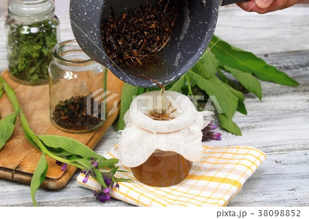 Alternative medicine, filtering comfrey ointment 38098852