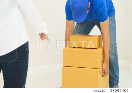 Deliveryman holding boxes into customer home - receiving packag Deliveryman holding boxes into customer home - receiving packag 38099405