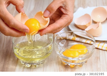 Woman hands breaking an egg Woman hands breaking an egg 38102395