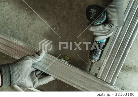 Man assembles profile metal frame Man assembles profile metal frame 38103180
