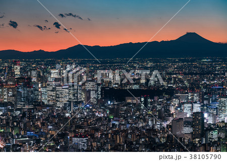 大都会東京の夜景と富士山のシルエットの写真素材