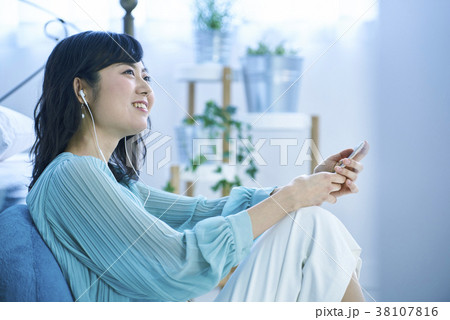 スマホとイヤホンで音楽を聴く女性 スマホとイヤホンで音楽を聴く女性 38107816