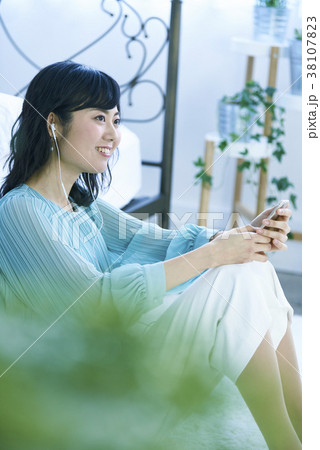 スマホとイヤホンで音楽を聴く女性 スマホとイヤホンで音楽を聴く女性 38107823