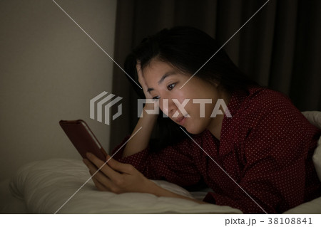 ベッドでスマホを見る若い日本人女性 ベッドでスマホを見る若い日本人女性 38108841