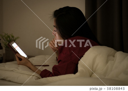 ベッドでスマホを見る若い日本人女性 38108843