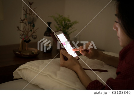 ベッドでスマホを見る若い日本人女性 ベッドでスマホを見る若い日本人女性 38108846