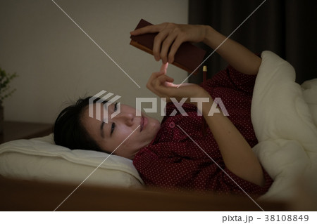 ベッドでスマホを見る若い日本人女性 38108849