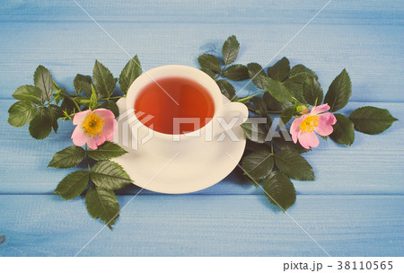 Cup of tea and wild rose flower on boards Cup of tea and wild rose flower on boards 38110565