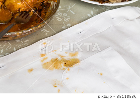 Plate of curry chicken and white shirt with stain. Plate of curry chicken and white shirt with stain. 38118836
