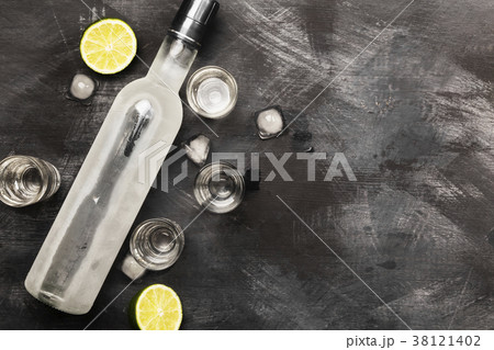 Cold vodka in shot glasses on a black background Cold vodka in shot glasses on a black background 38121402