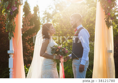 Couple under textile arch at soft sunset light 38121780