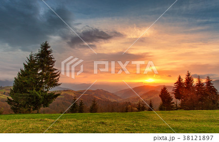 Spring colorful sunset. Green hills. Spring land 38121897