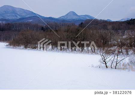 全面凍結の御所湖と周囲の山並みの雪景色 38122076