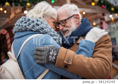 Affectionate elderly man and woman hugging outside Affectionate elderly man and woman hugging outside 38124249