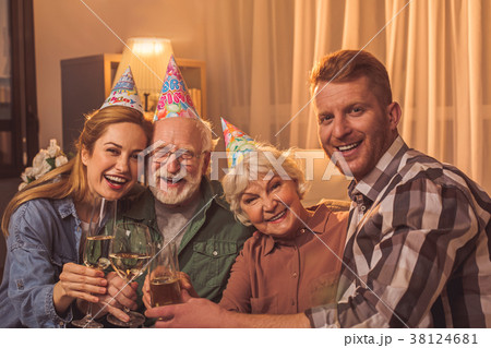 Smiling family celebrating birthday in apartment Smiling family celebrating birthday in apartment 38124681