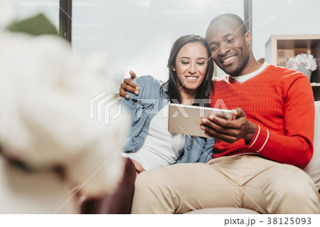 Married couple staring at tab indoors 38125093