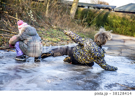 Little boy has a side-slip on the ice 38128414