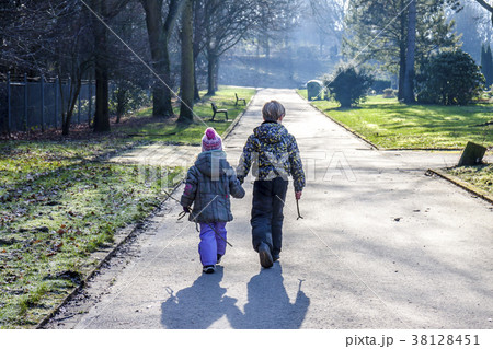 Little boy and girl holding hands and walking a 38128451
