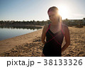 Girl stands on the beach against the sunset. 38133326