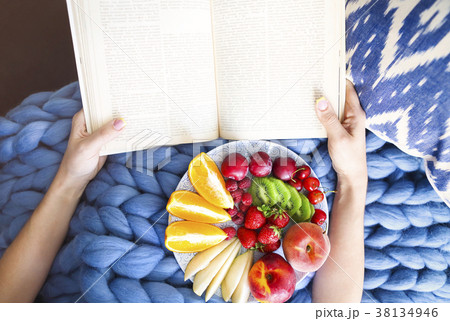Plate with fresh fruit on a blue plaid and book 38134946
