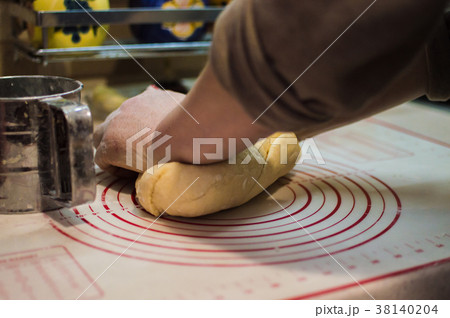 female hands kneading wheat dough for the cake. 38140204
