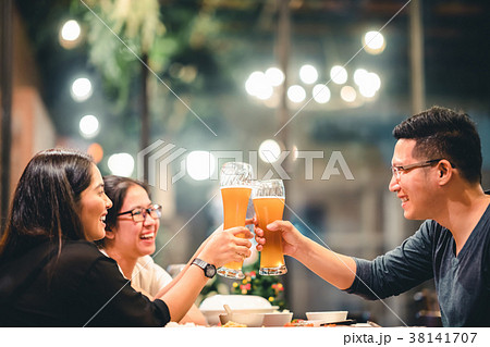 Asian friends cheering with beer at restaurant Asian friends cheering with beer at restaurant 38141707
