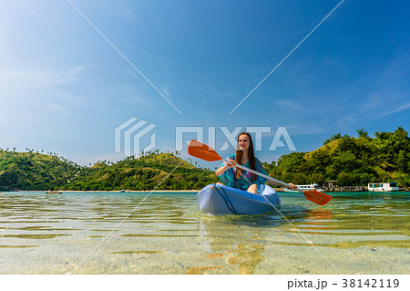 Young woman paddling during vacation in an idyllic Young woman paddling during vacation in an idyllic 38142119
