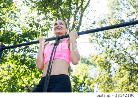 Cheerful young woman wearing pink sports bra while 38142190