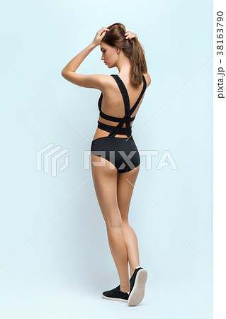 Rear view of beautiful young girl in back swimsuit posing in stu 38163790