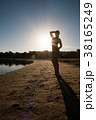 Sweet girl stands on the beach against the sunset. 38165249