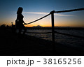 Silhouettes of girl standing on pier near the sea 38165256