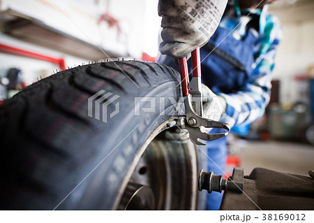 Senior female mechanic repairing a car in a garage Senior female mechanic repairing a car in a garage 38169012