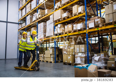 Two young workers in a warehouse. 38169283