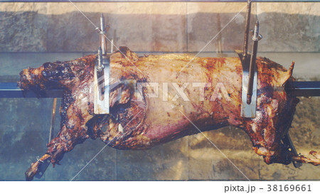 whole roasted pig on spit, harmful fatty food 38169661