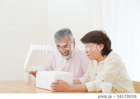 小包を開けて困惑する老夫婦　配送トラブル　送りつけサギ　シニア　シルバー世代　おじいさんとおばあさん 38170039