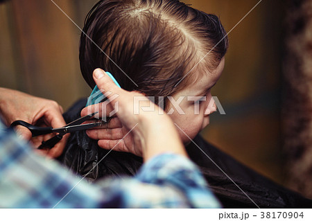A little boy is trimmed in the hairdresser's A little boy is trimmed in the hairdresser's 38170904