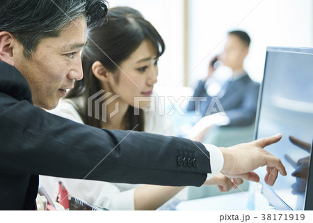 画面を指さしながら会話をするビジネス男女 画面を指さしながら会話をするビジネス男女 38171919