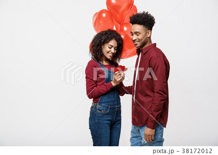 Portrait of young couple in love holding red paper 38172012