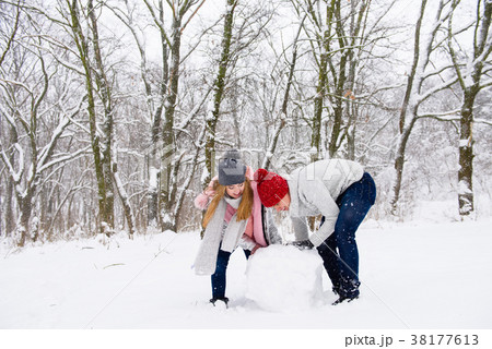 Young couple making snowman in forest 38177613