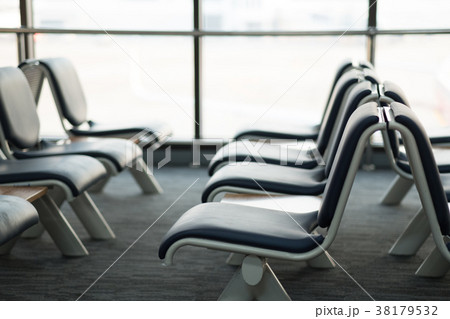Empty airport terminal waiting area with chairs  38179532