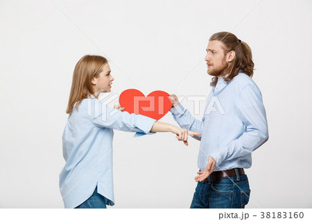 Couple holding heart shape paper with angry facial Couple holding heart shape paper with angry facial 38183160